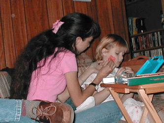 Amanda getting her face painted by her cousin on March 24, 2002
